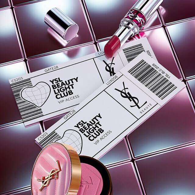 YSL Beauty-producten (lipstick en blush) geschikt met ticket-stijl VIP-toegangskaarten op een reflecterend metalen oppervlak.