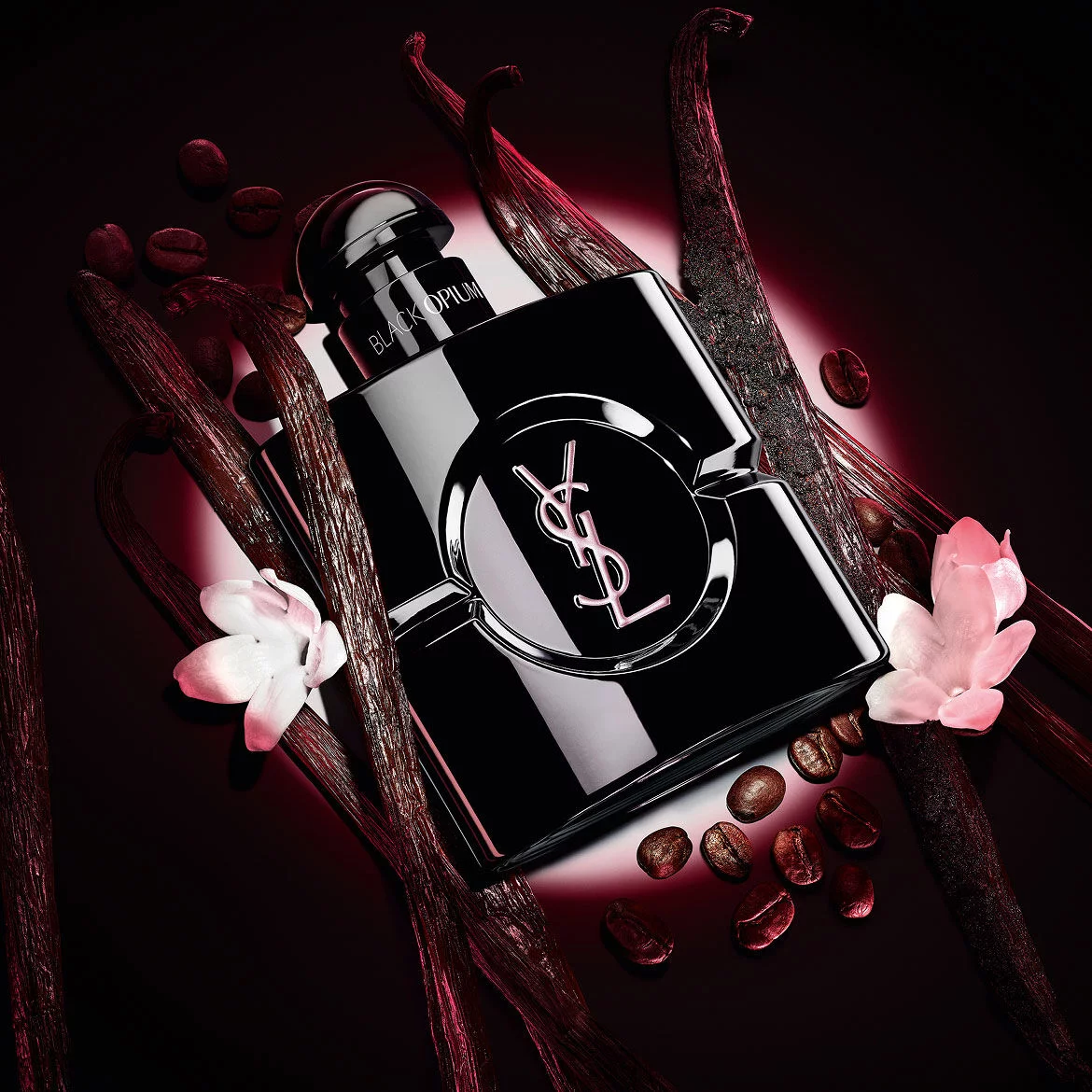 Black Opium Le Parfum-flacon in glanzend zwart, omringd door donkere vanillepeulen en witte jasmijn.