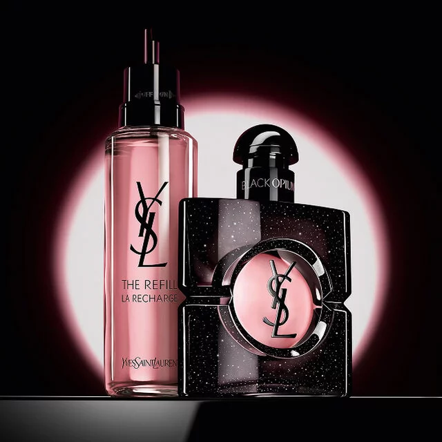 Black Opium Eau de Parfum-flacon naast de glazen navulflacon van 100 ml met het YSL-logo.