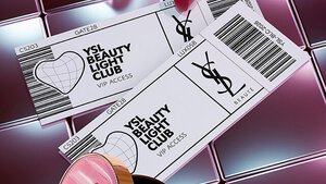 YSL beautyproducten waaronder een doorgestikt compactpoeder, mascara en twee lipsticks tegen een glanzende roze tegelachtergrond.