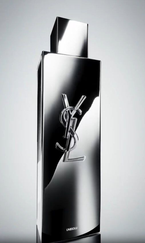 YSL Y L'ABSOLU parfumfles omringd door donker hout, witte oranjebloesem, gember en kardemompeulen.