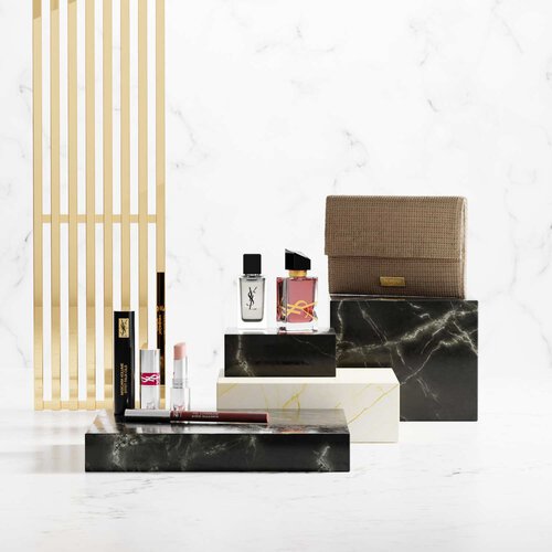 YSL-schoonheidsproducten op luxe marmeren sokkels.