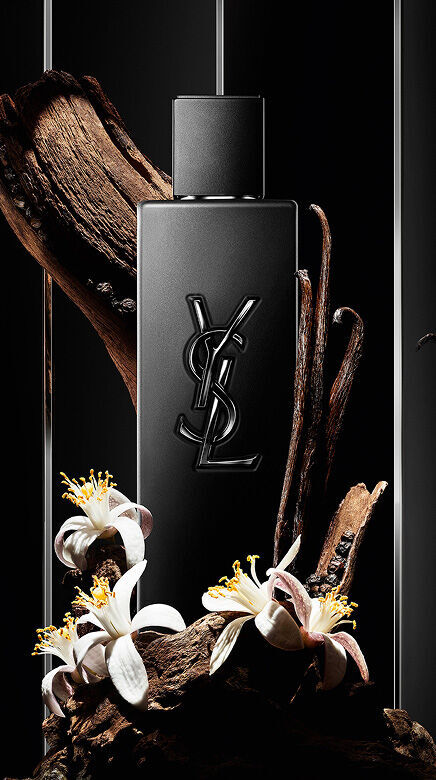 Zwarte YSL parfumfles omringd door hout, vanillepeulen en witte bloemen.