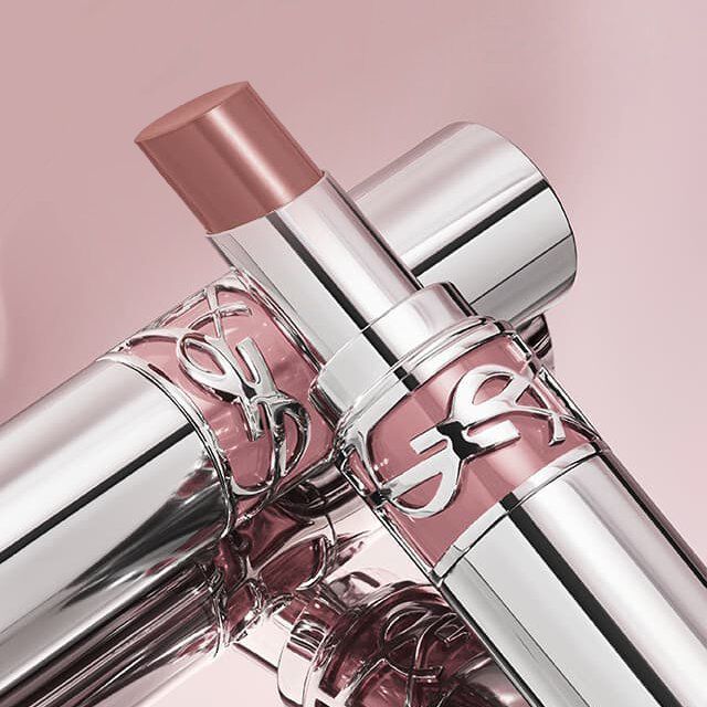 Twee zilveren en roze YSL lippenstiften, een open met een nude tint.