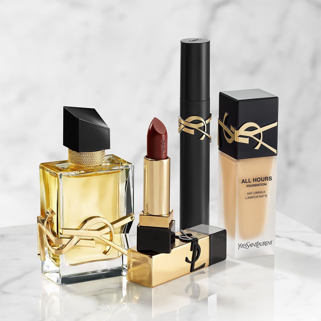 YSL schoonheidsproducten: parfum, lippenstift, mascara en foundation op marmer.