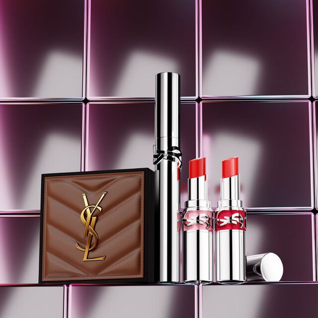 YSL beautyproducten waaronder een doorgestikt compactpoeder, mascara en twee lipsticks tegen een glanzende roze tegelachtergrond.