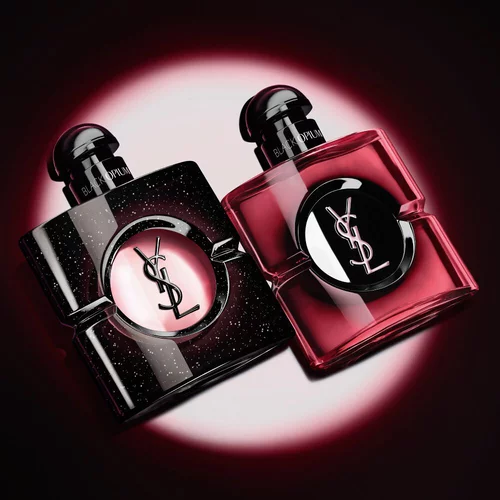 Twee verlichte Yves Saint Laurent Black Opium parfumflacons tegen een donkere achtergrond.