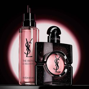 Een hand die een gouden refill-flacon vasthoudt tegen een neutrale achtergrond. Links staat in witte tekst in penseelstijl "Join the REFILL Movement", en rechts wordt een klassieke glazen YSL Libre parfumflacon met het kenmerkende gouden logo getoond.