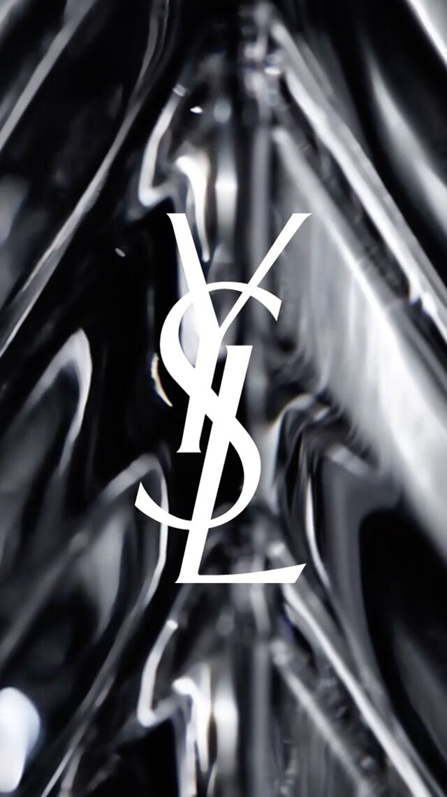 Wit YSL-logo op een zwarte, facetgeslepen glazen achtergrond.