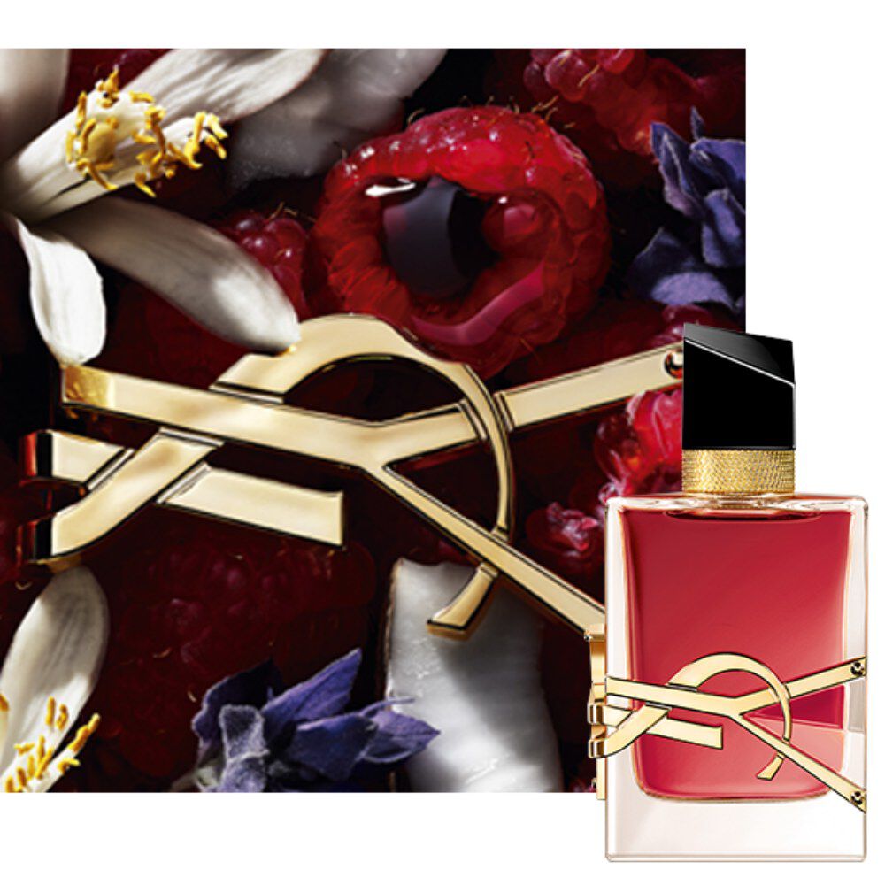 Close-up van de Libre Berry Crush-flacon met gouden YSL-logo, omringd door rode bessen en florale elementen.
