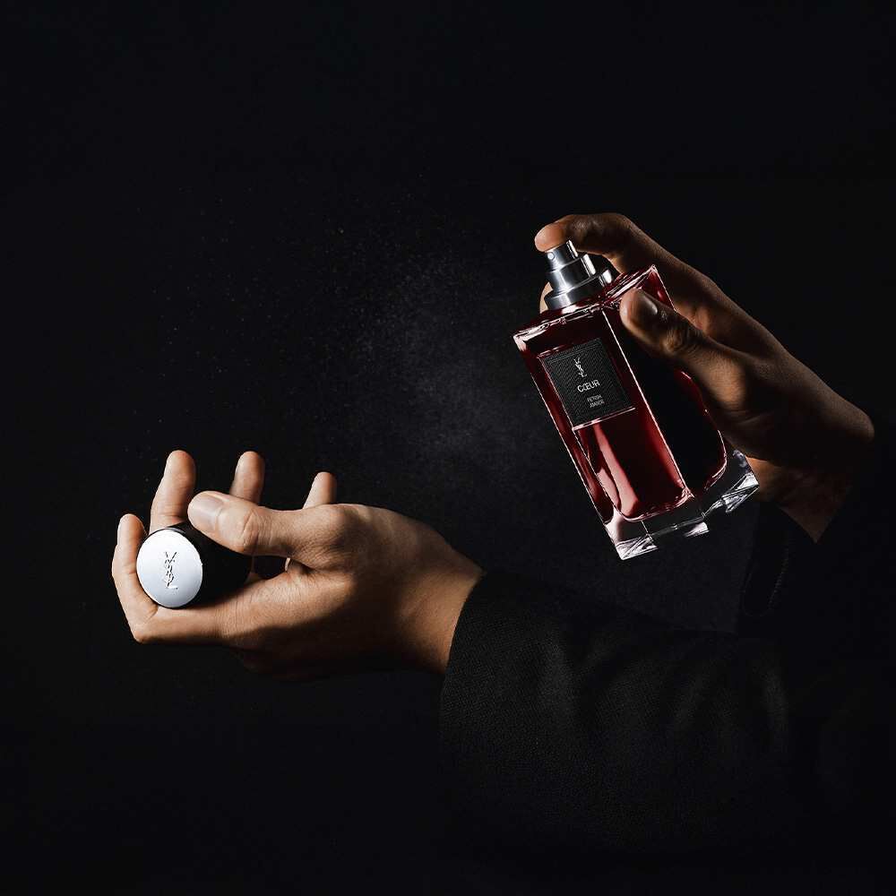 Iemand sprayt YSL "Coeur Battant" parfum op de pols.​
