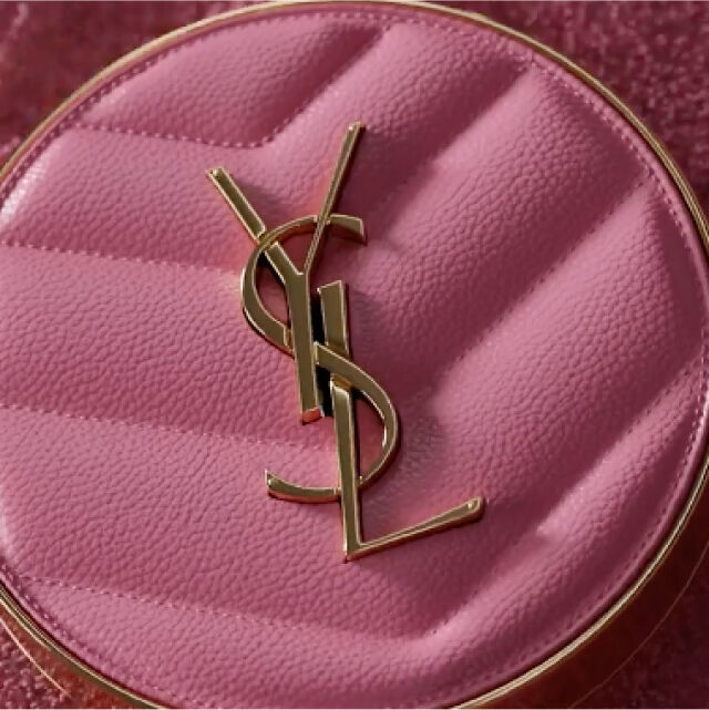 Close-up of a pink handbag featuring the gold "YSL" logo.