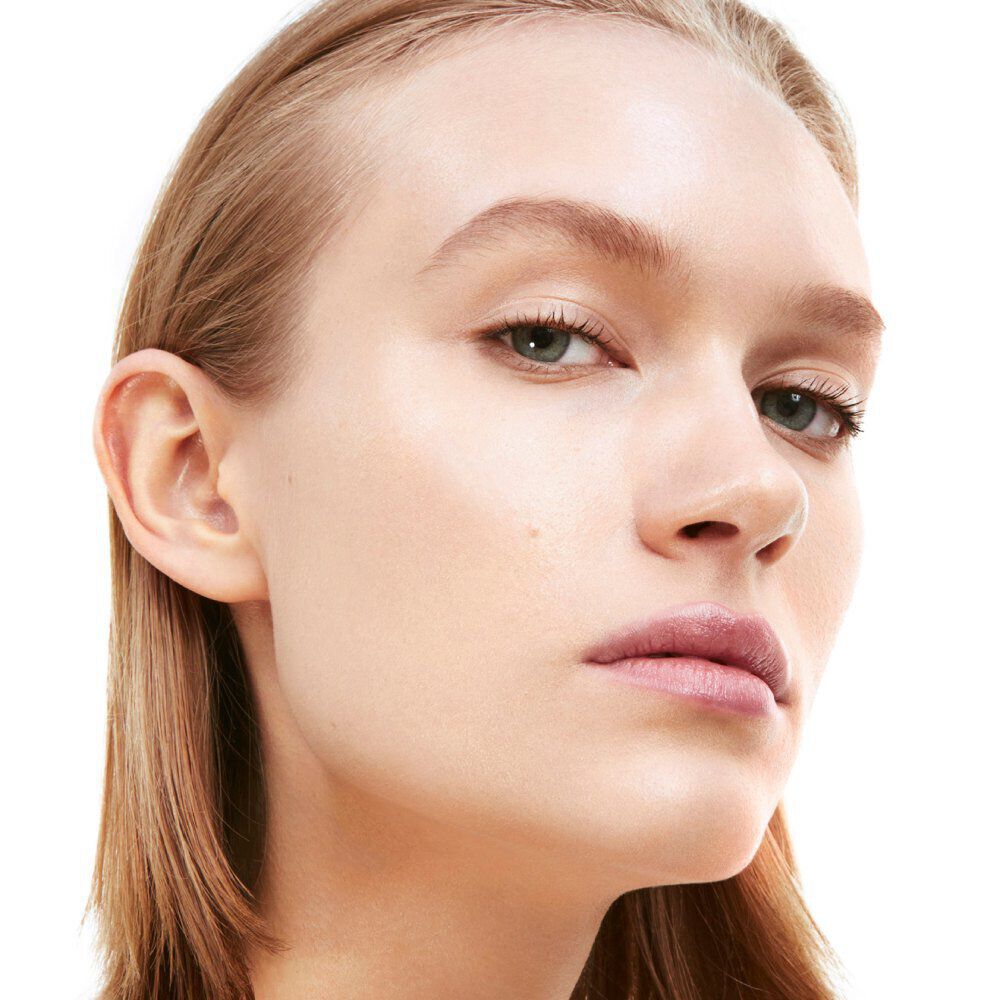 A close-up portrait of a person with straight hair, highlighting their face and features, including smooth skin and subtle makeup.