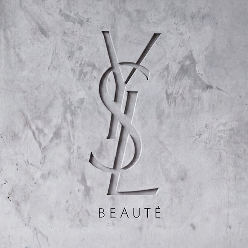 YSL BEAUTE-logo gegraveerd in een grijze betonnen muur met textuur.