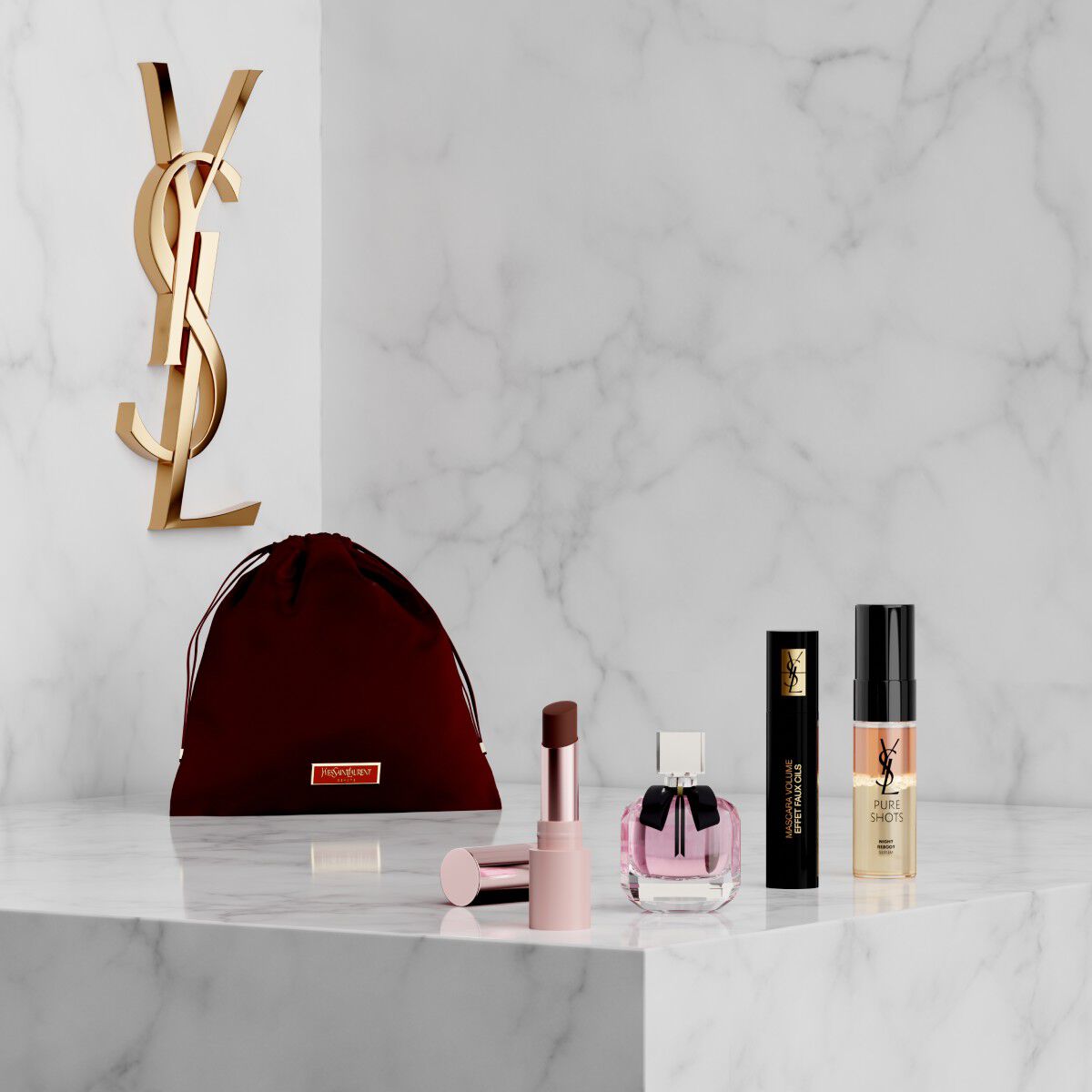 YSL Beauty-set met roze etui, lipstick, eyeliner, mascara en mini parfum op een marmeren plank.