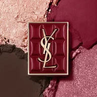 YSL Couture Mini Clutch-palet tegen een gestructureerde achtergrond van sprankelende oogschaduwpoeders in #1982 Burgundy Millesime.