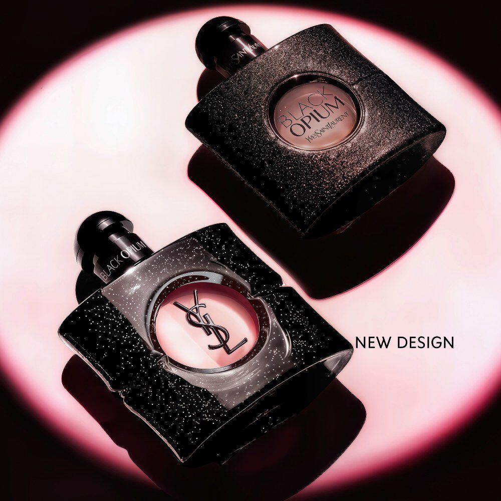 Black Opium Eau de Parfum-flacon liggend op zijn zij op een donker oppervlak met een roze lichthalo.