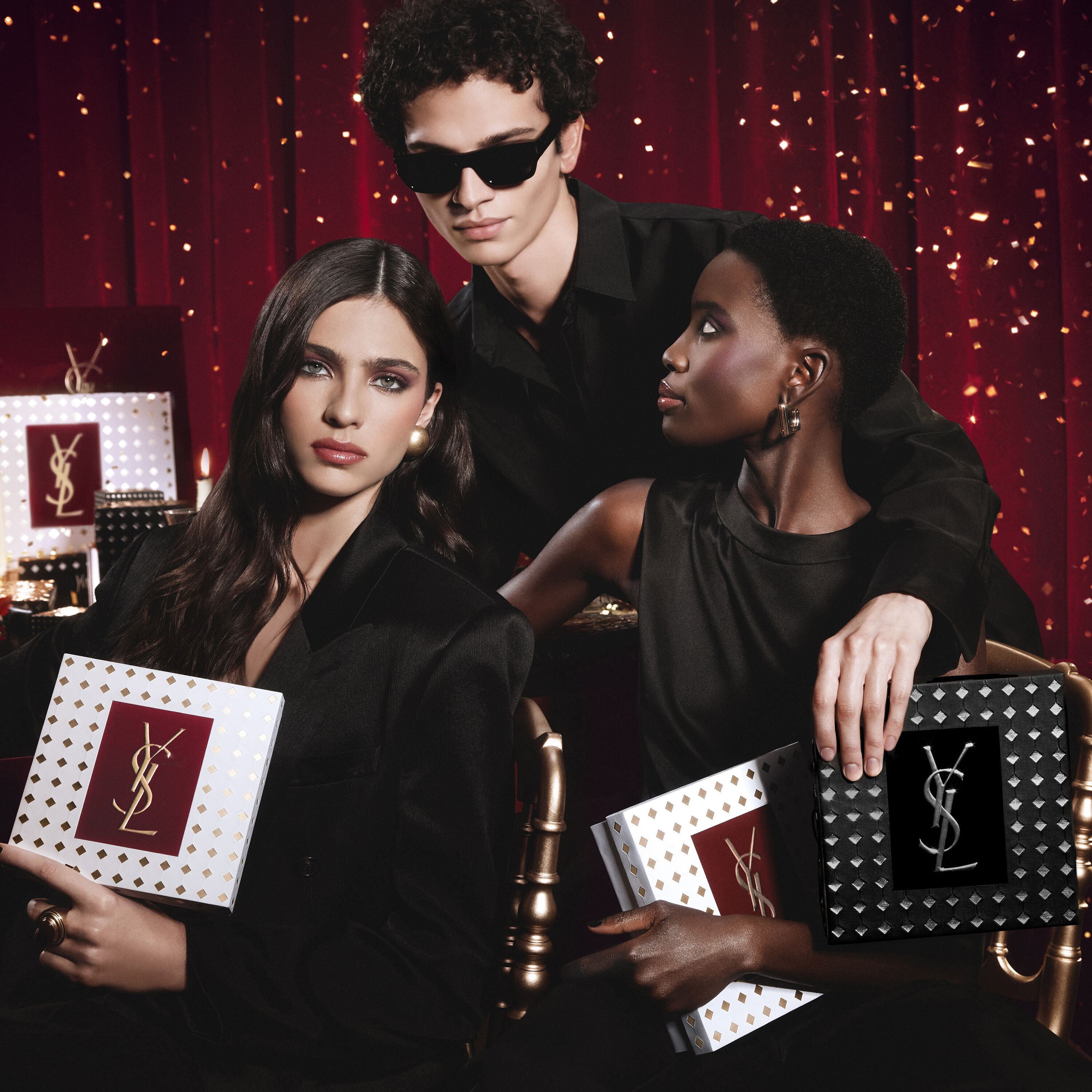 Modellen poseren samen, luxe YSL Holiday cadeauverpakkingen vasthoudend in een feestelijke sfeer.