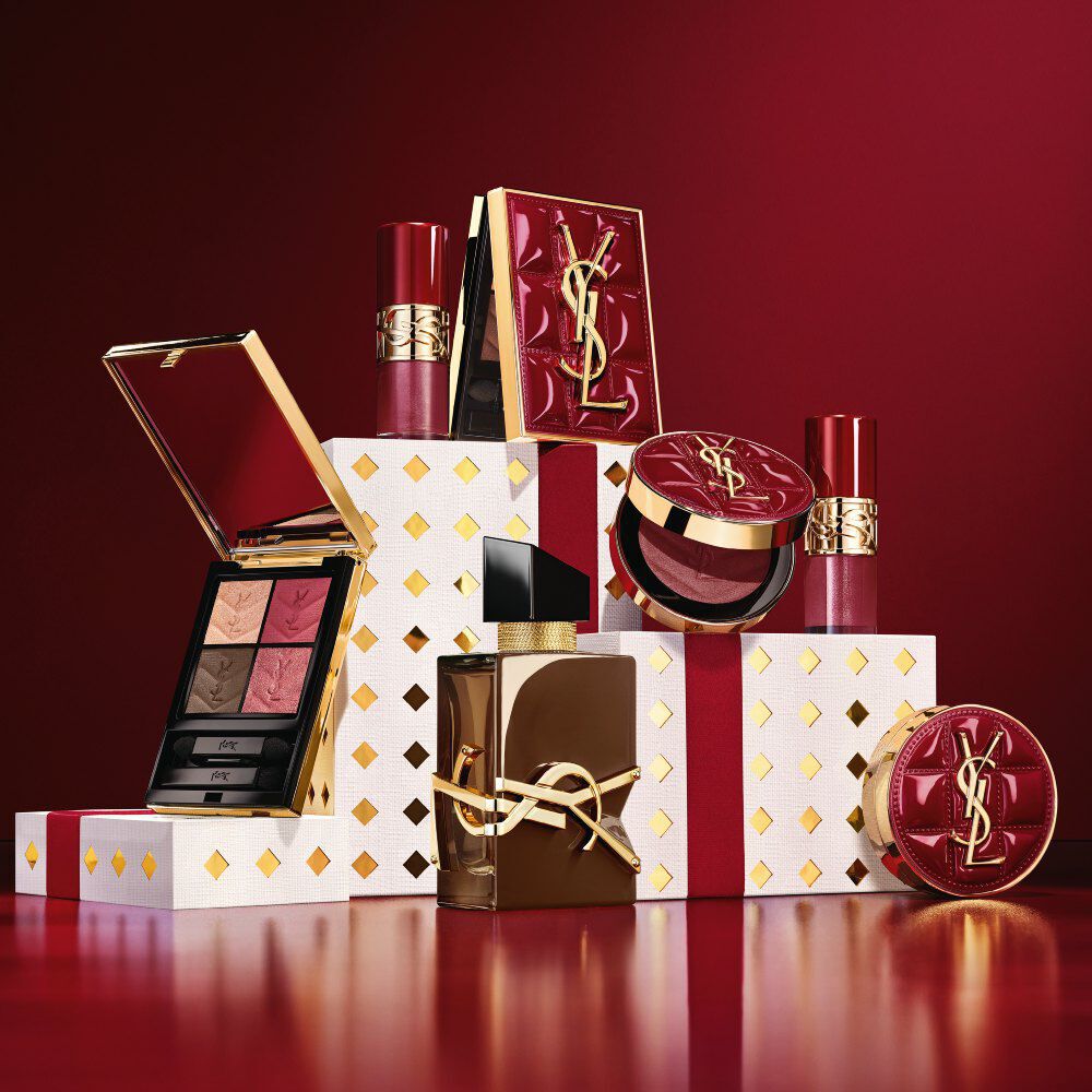 YSL Beauty feestcollectie 2026 make-up en geurenset op gouden gepolijste witte sokkels in bordeauxrood.