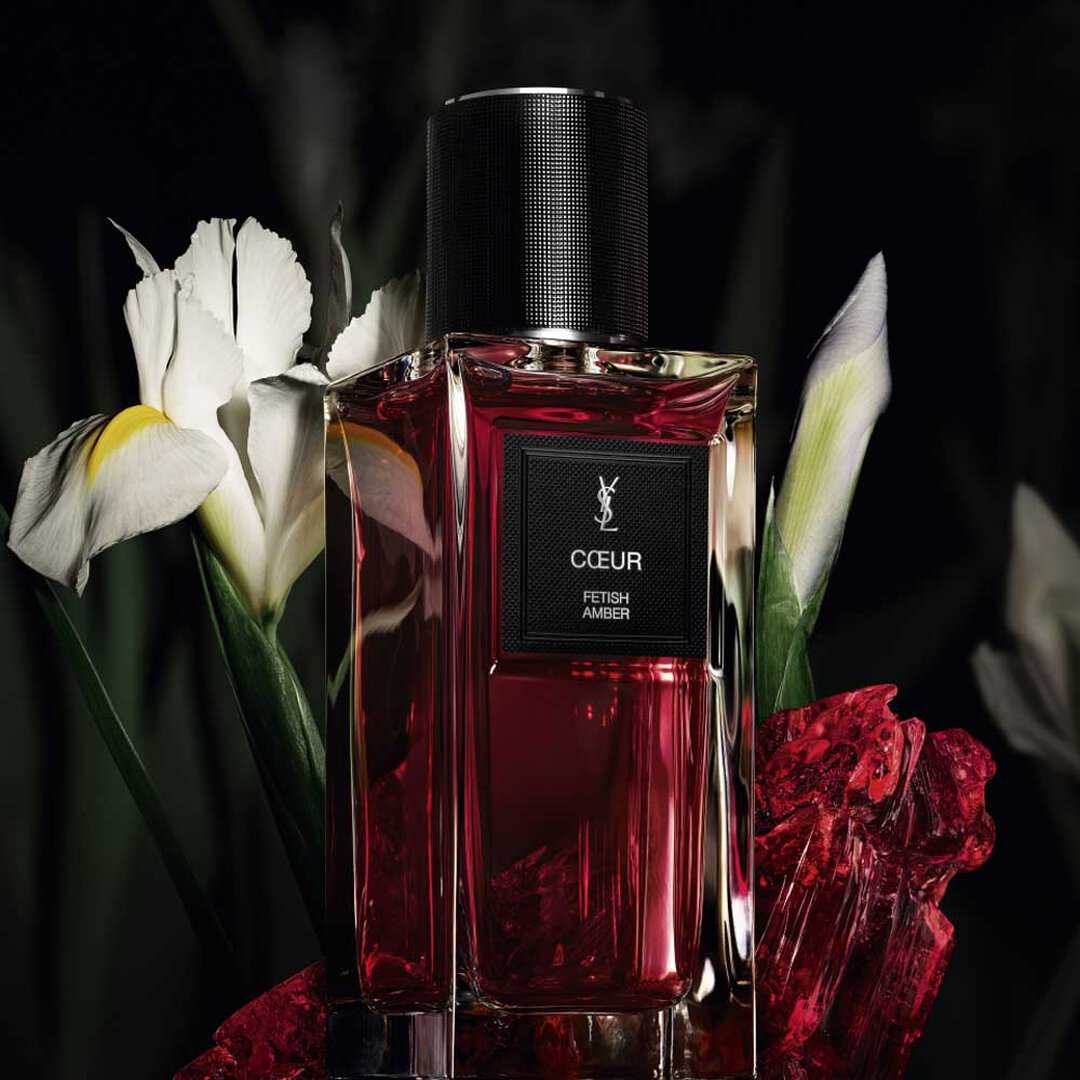 Rode YSL-parfumfles met witte bloemen.