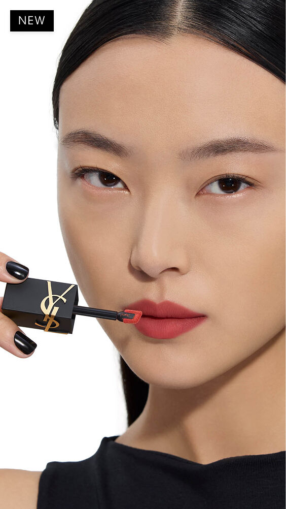 Aziatische model met een lichte huidskleur brengt een warme rode tint van YSL THE INKS BLUR lippenvlek aan met de applicator.