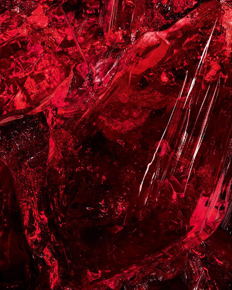 Macro-opname van een getextureerd rood amberkristal,
een sleutelingrediënt van CŒUR Eau
de Parfum van YSL, dat zijn ruwe
diepte toont.