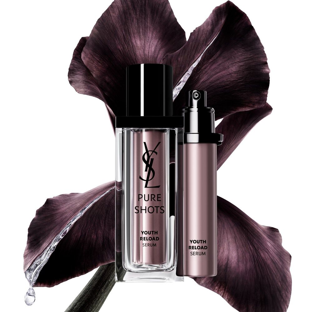 YSL Beauty Pure Shots Youth Reload Serum en zijn duurzame navulling, gepositioneerd tegen een donkerpaarse irisbloem.