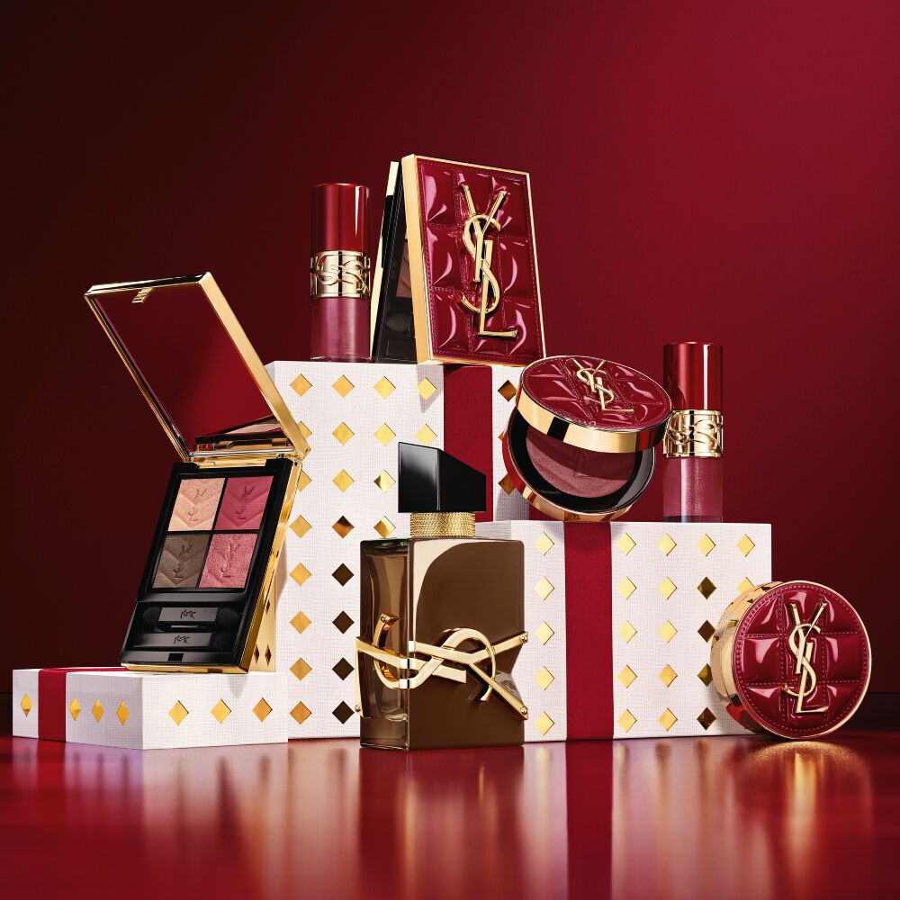 YSL Holiday 2026 make-upcollectie en geurenset op wit met gouden stippen voetstukken in bordeauxrood.