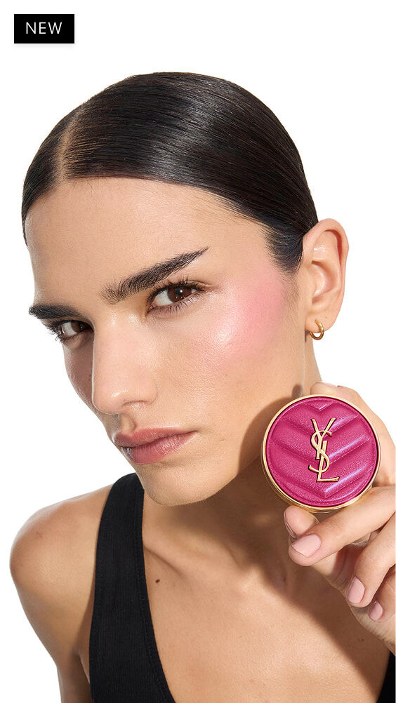 Iman, getinte huid, houdt een fuchsia YSL Make Me Blush poederblush vast in tint 66.