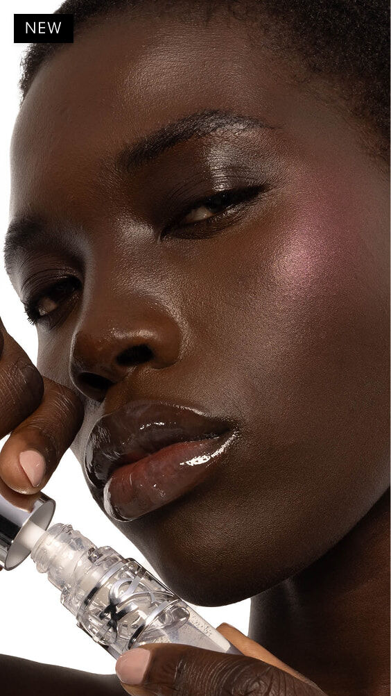 Nyaluak, donkere huid, met YSL LOVESHINE Plumping Lip Oil Gloss in tint 11 Radiant Glass.