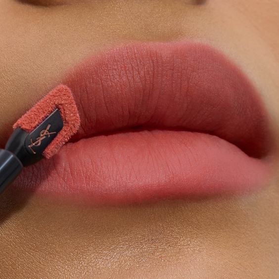Close-up van zachte, matte roze-roze lippen die nauwkeurig worden afgelijnd met de schuine, platte applicatortip van de YSL lipstain.