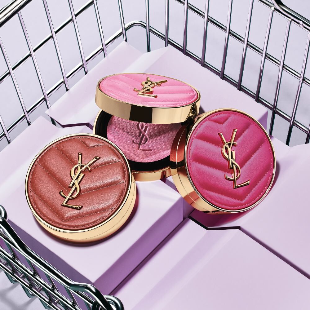 Drie YSL Make Me Blush poederblushes in de tinten 10, 12 en 66 gepresenteerd op paarse blokken.