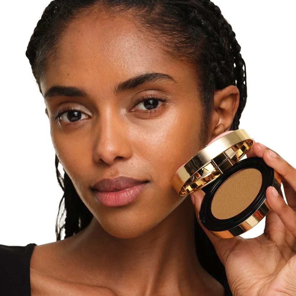 Model met medium huidskleur die YSL SKIN AFFAIR SOFT GLOW CUSHION vasthoudt. Stralende, egale en natuurlijk ogende teint.