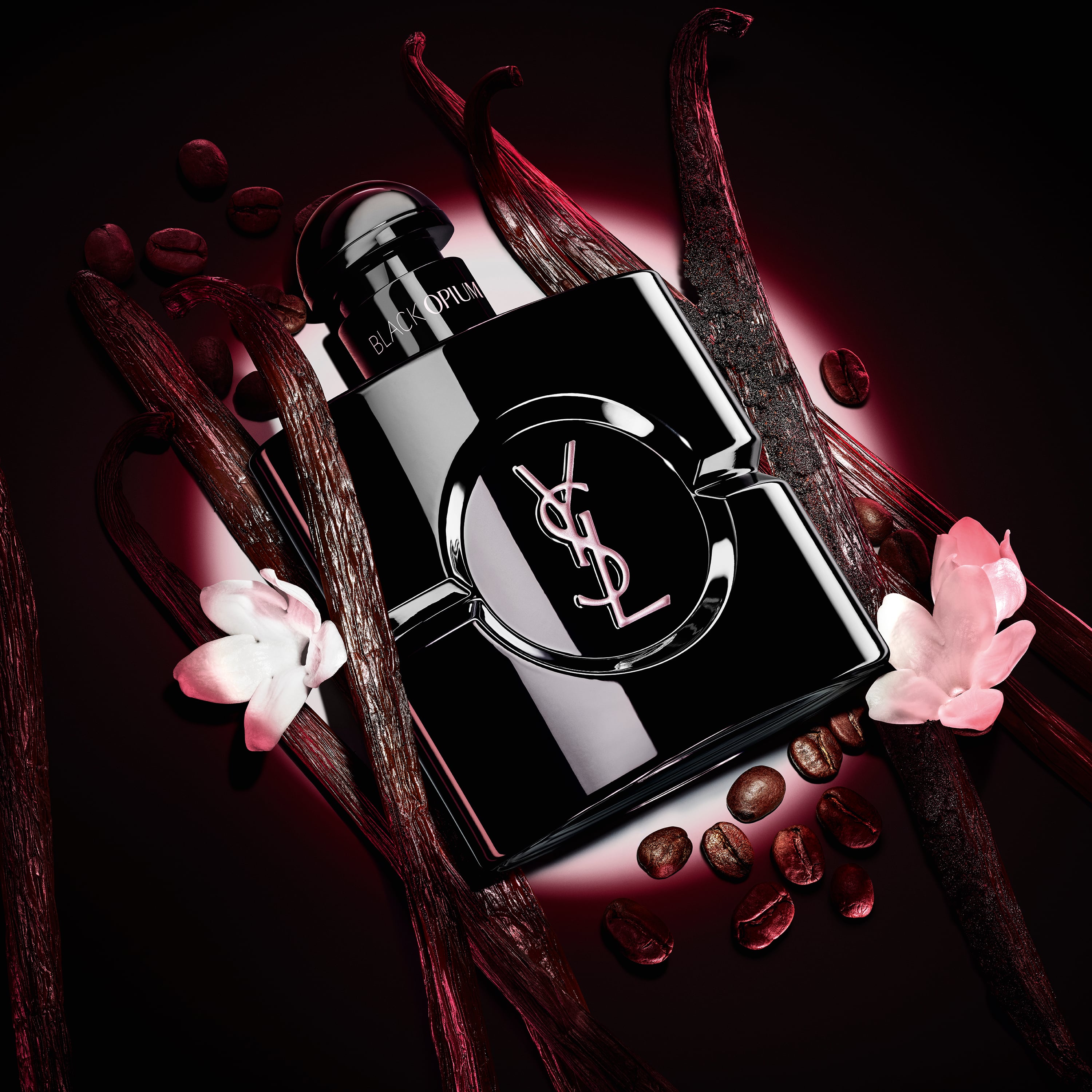 Black Opium Le Parfum-flacon in glanzend zwart, omringd door donkere vanillepeulen en witte jasmijn.