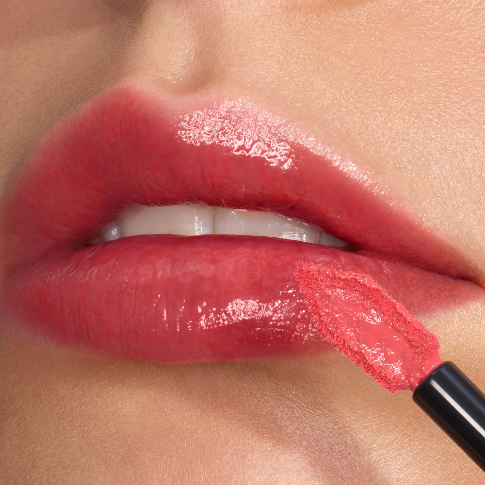 Close-up van glanzende lippen met een intense shine, nauwkeurig gelijnd met de schuine, platte YSL applicator.