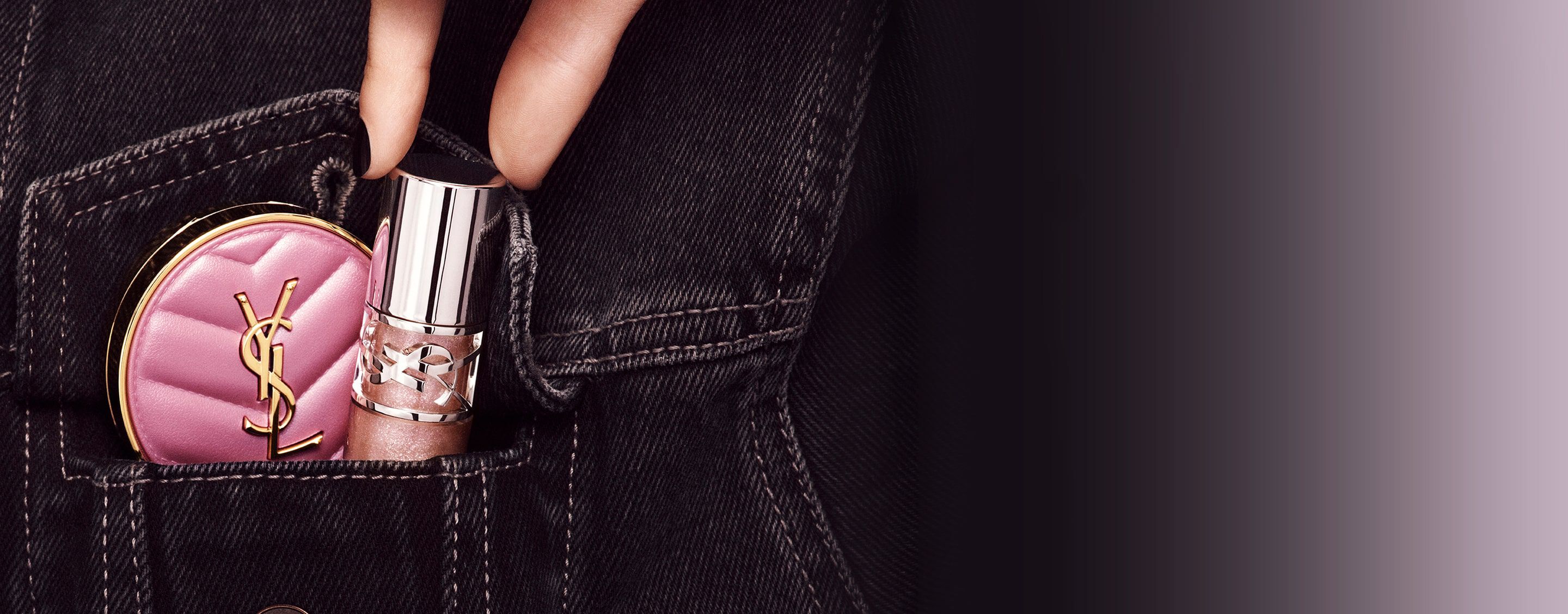 Hand die YSL LOVESHINE Lip Oil Gloss en roze Make Me Blush compact in een spijkerbroekzak steekt