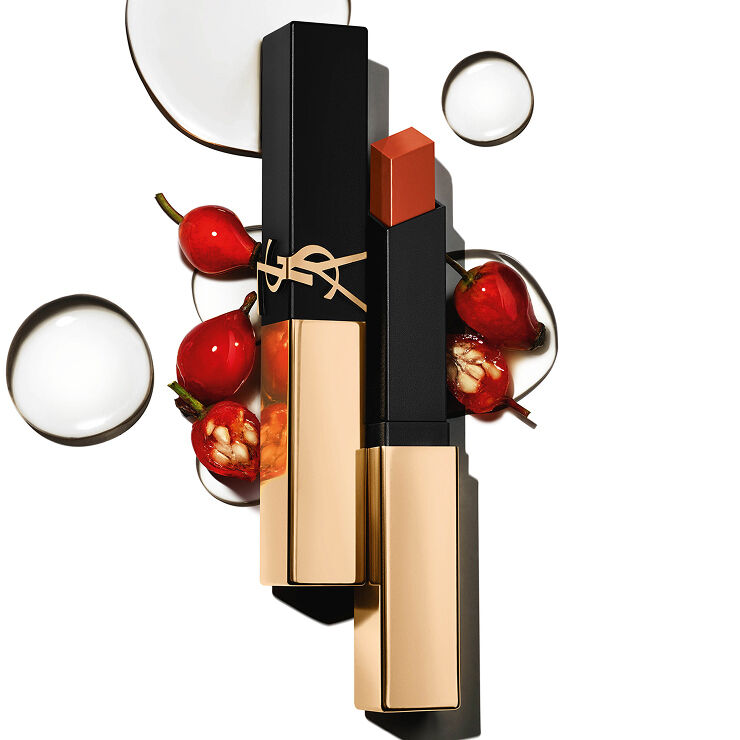 Vierkante YSL-lippenstift met gouden dop tussen rode bessen en heldere druppels op een witte achtergrond.
