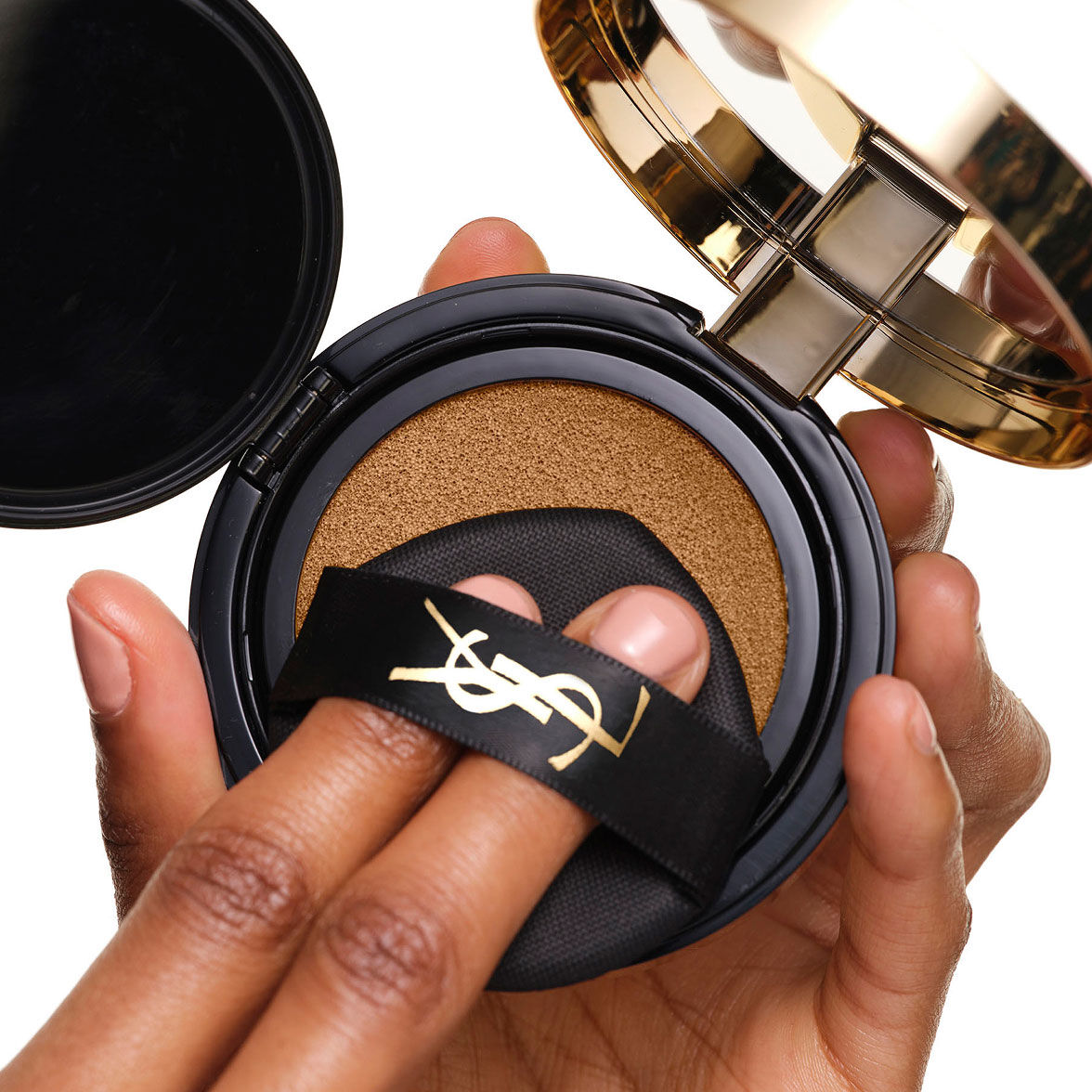 YSL SKIN AFFAIR SOFT GLOW CUSHION laden. Vingers onder het zwarte logo lint, drukend met de make-up puff.