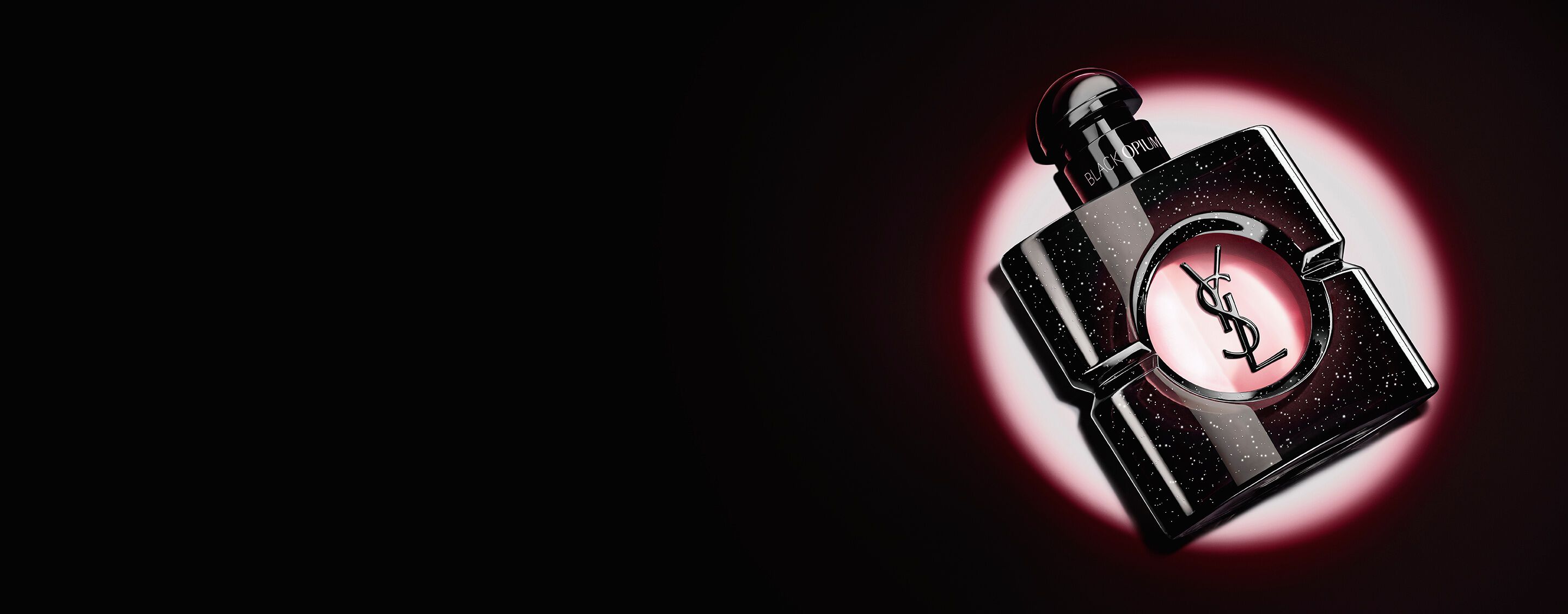 Black Opium Eau de parfum-flacon liggend op zijn kant op een donker oppervlak met een roze lichthalo.