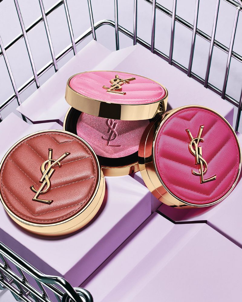 Drie YSL Make Me Blush poederblushes in de tinten 10, 12 en 66 gepresenteerd op paarse blokken.