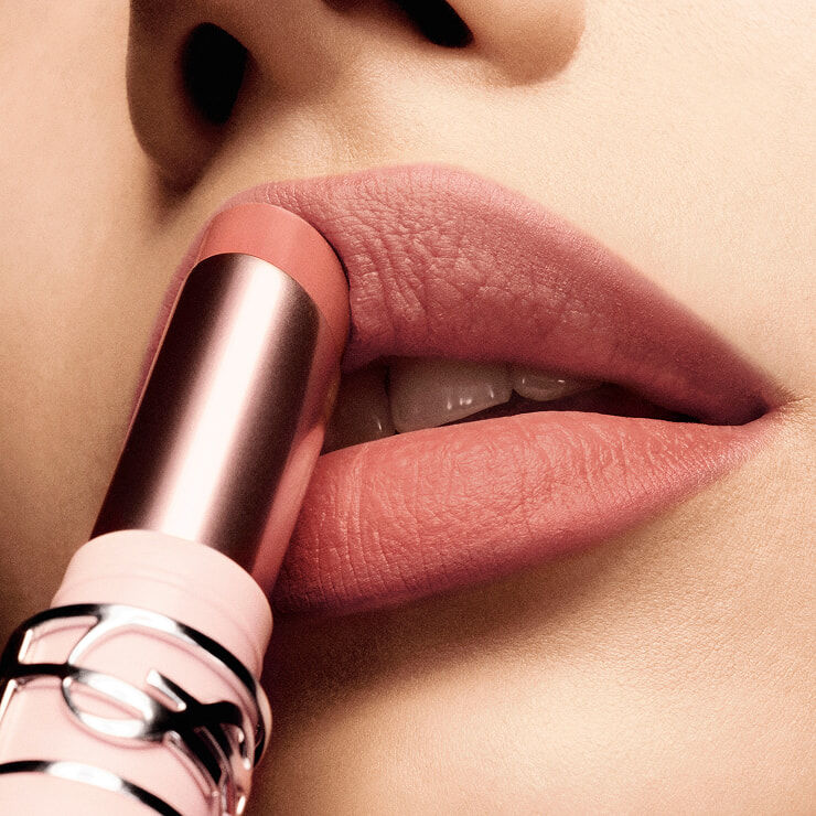 Close-up of lips applying YSL LOVENUDE Lip Blusher in shade 44, showcasing its smooth application.
