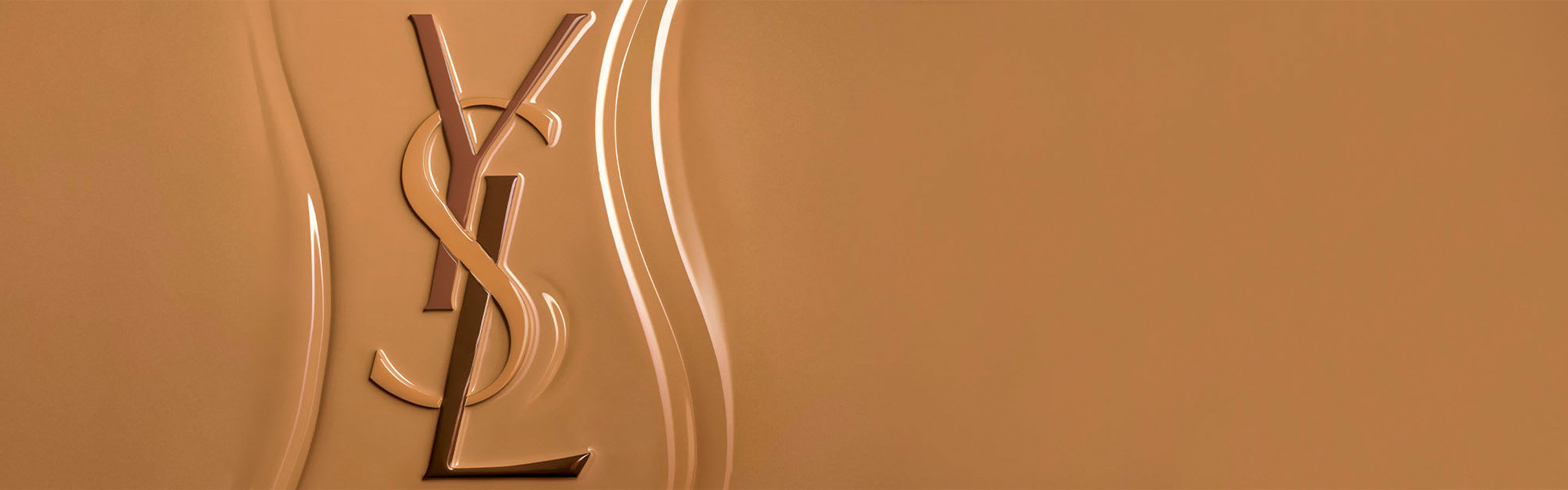 Yves Saint Laurent (YSL) logo in reliëf op een getextureerd oppervlak van vloeibare foundation, die de rijke, gemakkelijk te vervagen consistentie van het product benadrukt.